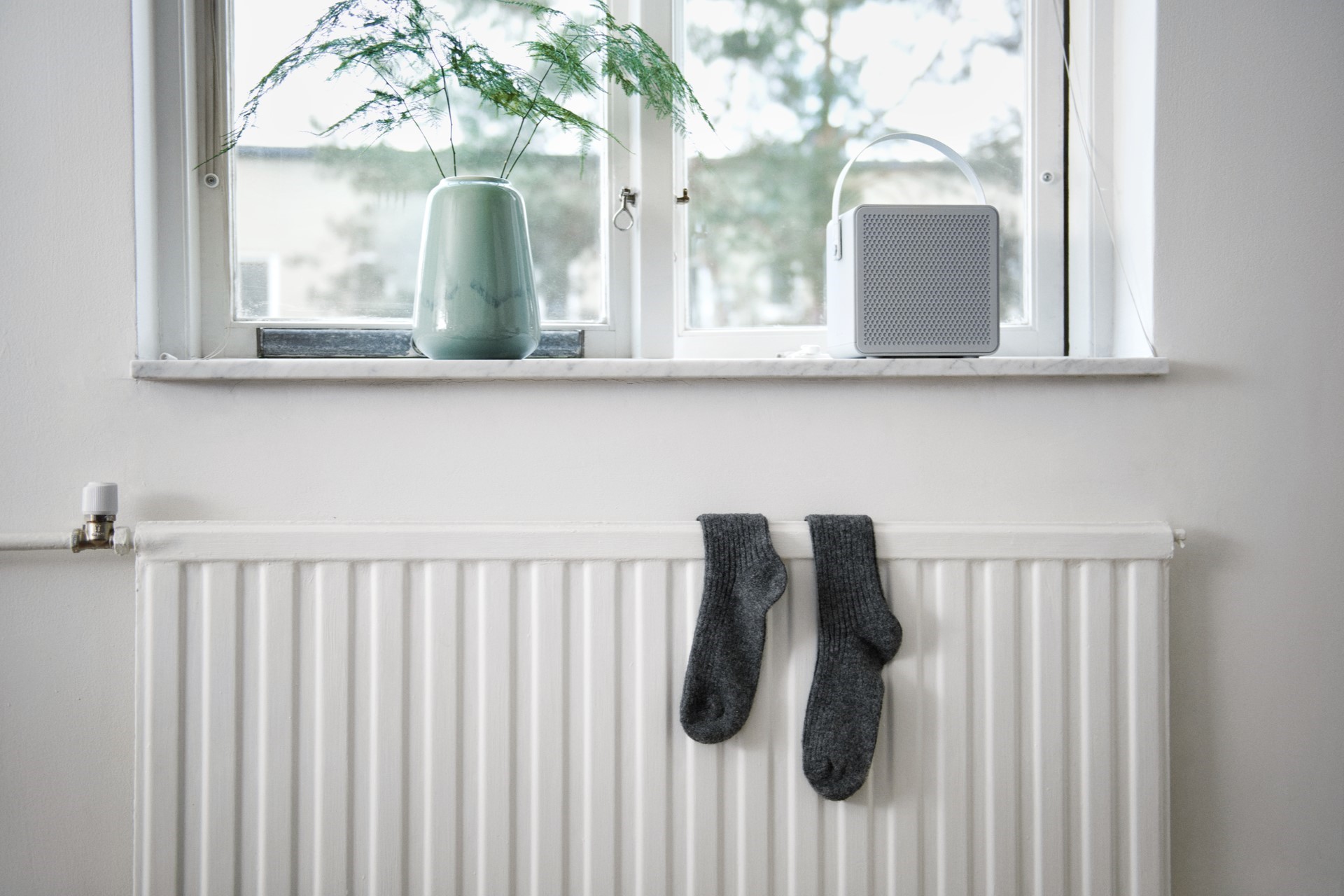 Een jongedame is bezig op haar thermostaat | Vattenfall over zelf je verwarming ontluchten