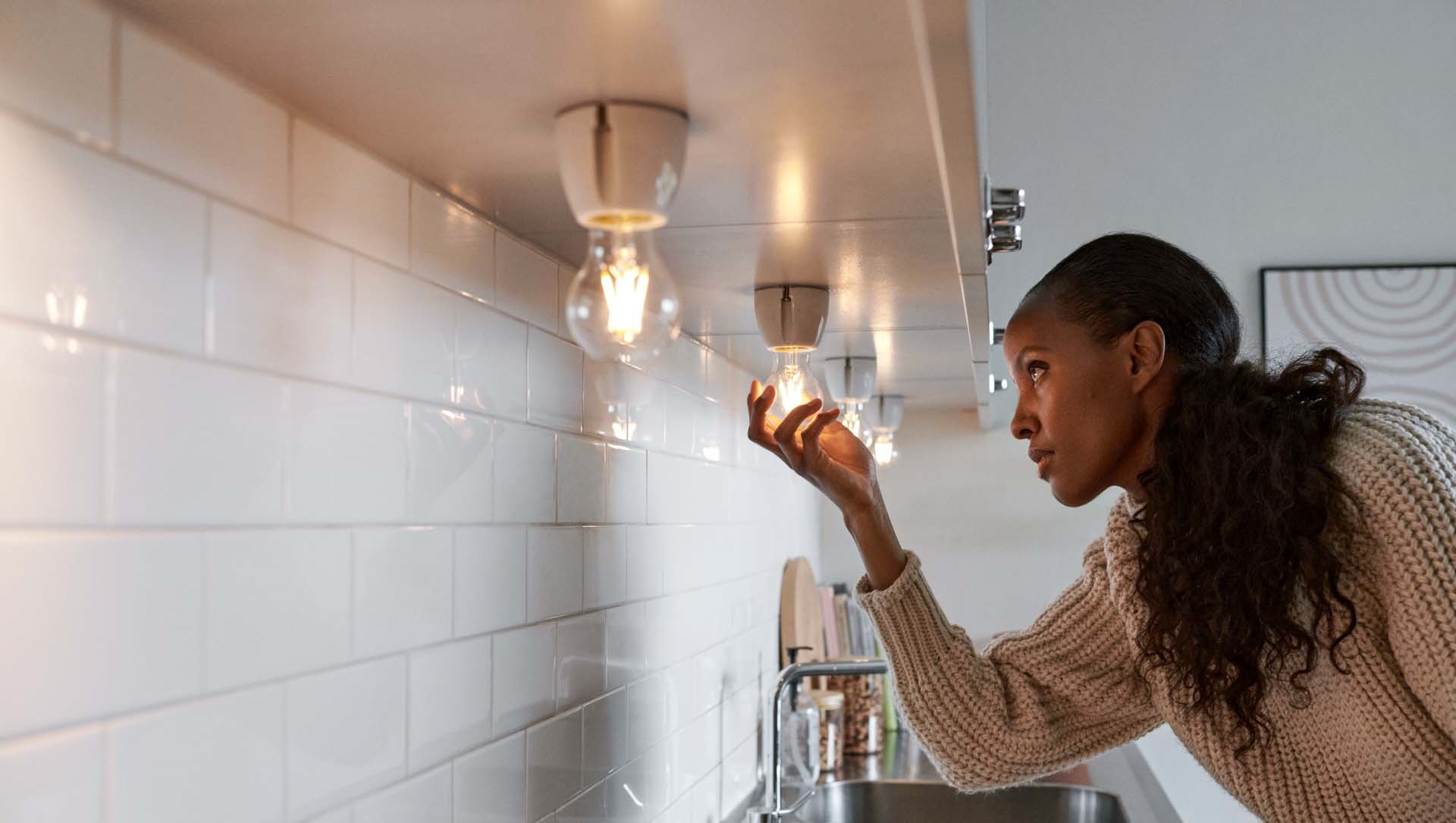 Mevrouw draait lamp in een fitting