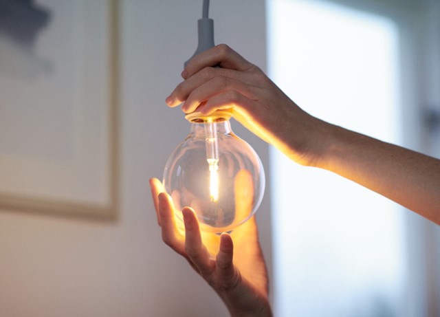 Close-up van handen die een lamp indraaien