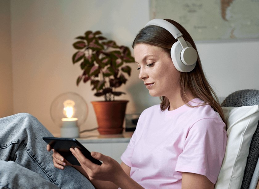 Vrouw leest op tablet met slimme lamp op de achtergrond