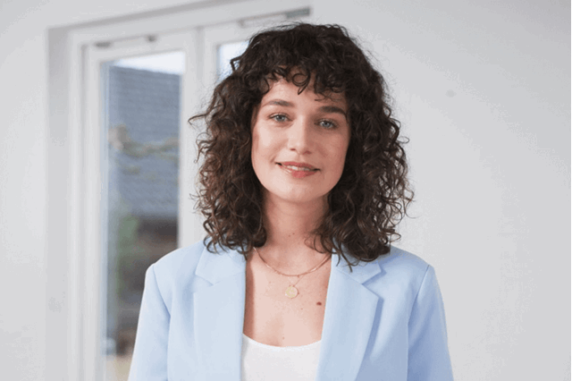 Vrouw in lichtblauw jasje legt uit over energieprijzen
