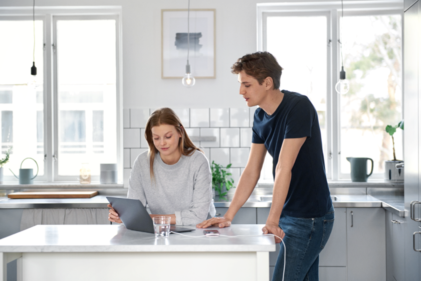 Man en vrouw kijken naar laptop in keuken