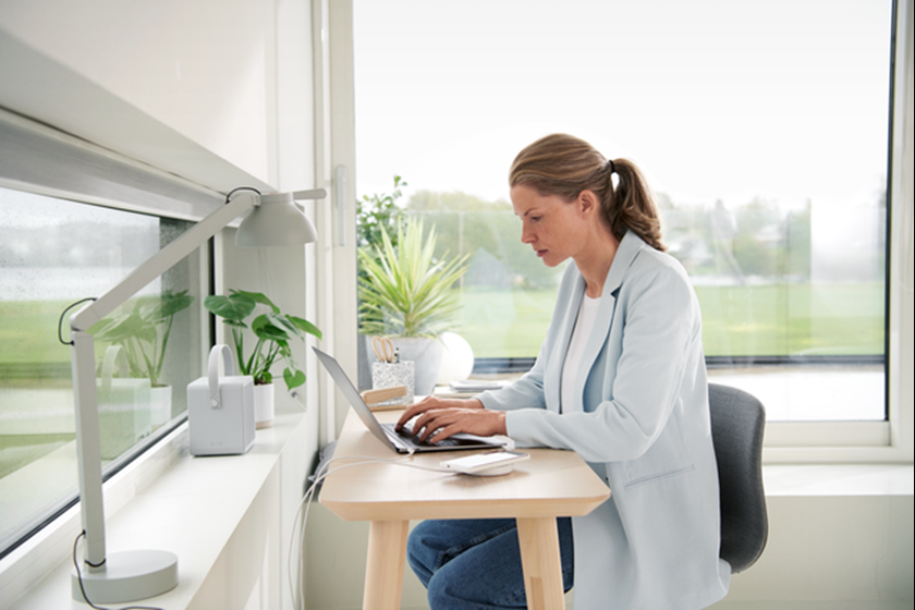 Vrouw zit thuis achter de computer