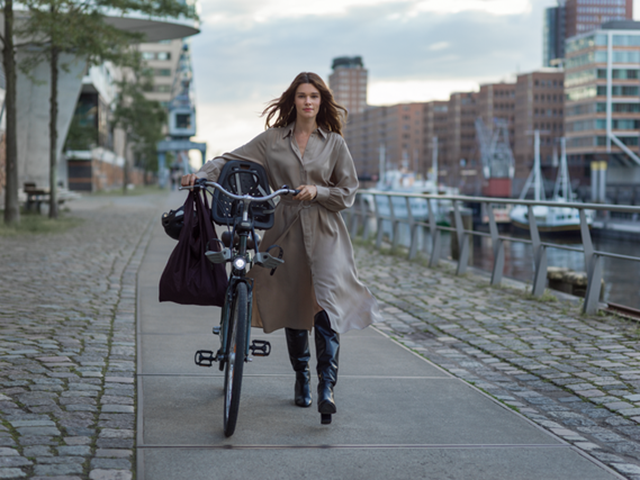 Vrouw loopt met fiets langs kade, Energie aanbiedingen: Mijn Vattenfall