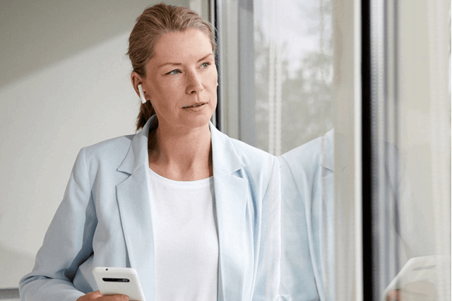Zakenvrouw met mobiel in de hand checkt zakelijke energie aanbiedingen