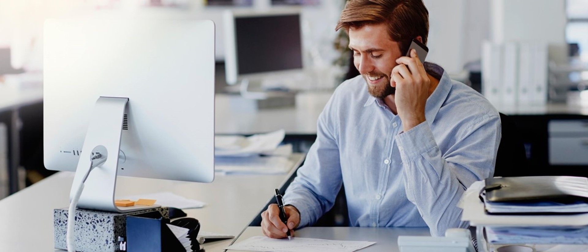 Man achter beeldscherm aan de telefoon