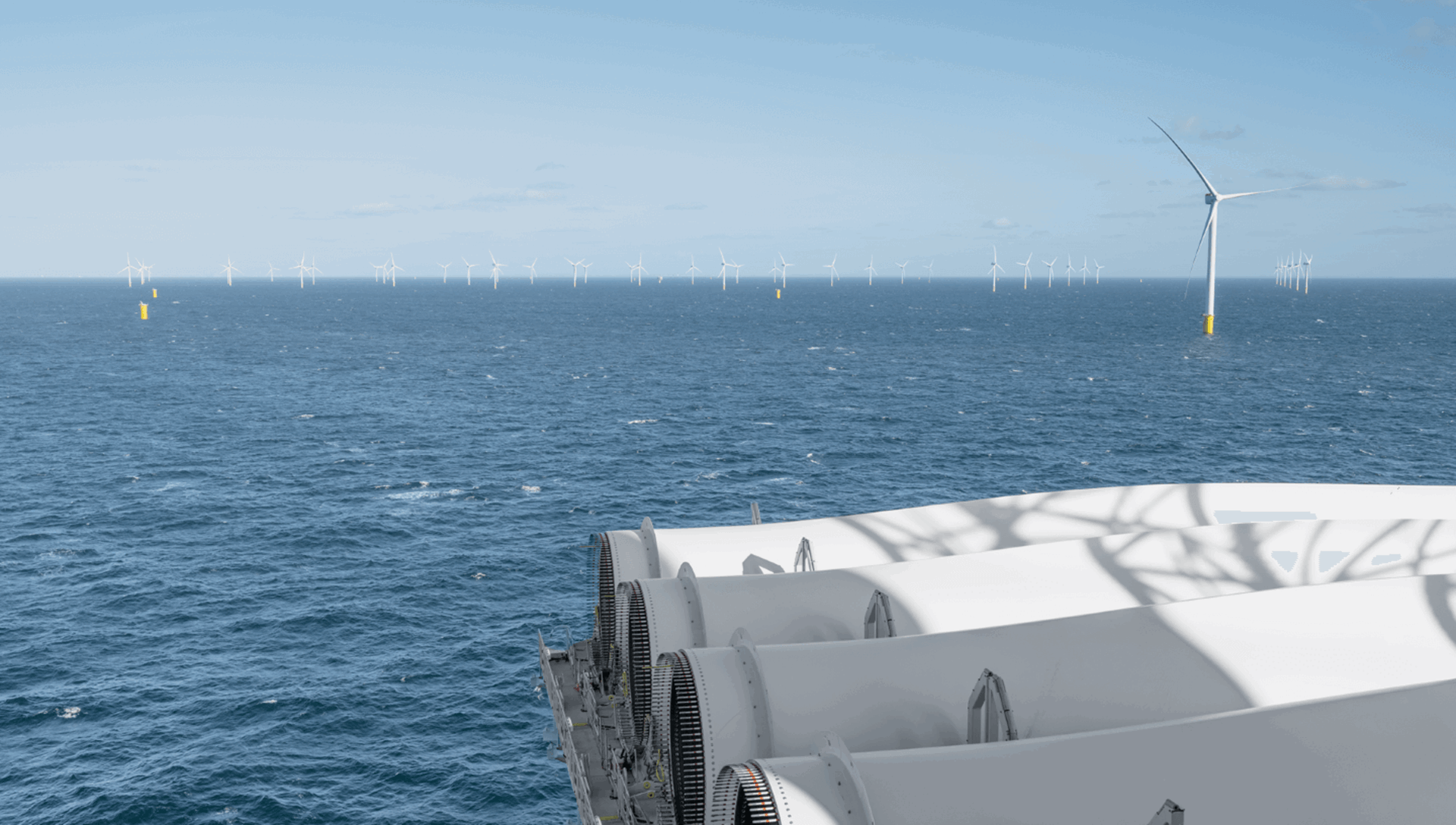 Windmolens op zee met op de voorgrond een aantal windmolens in aanbouw
