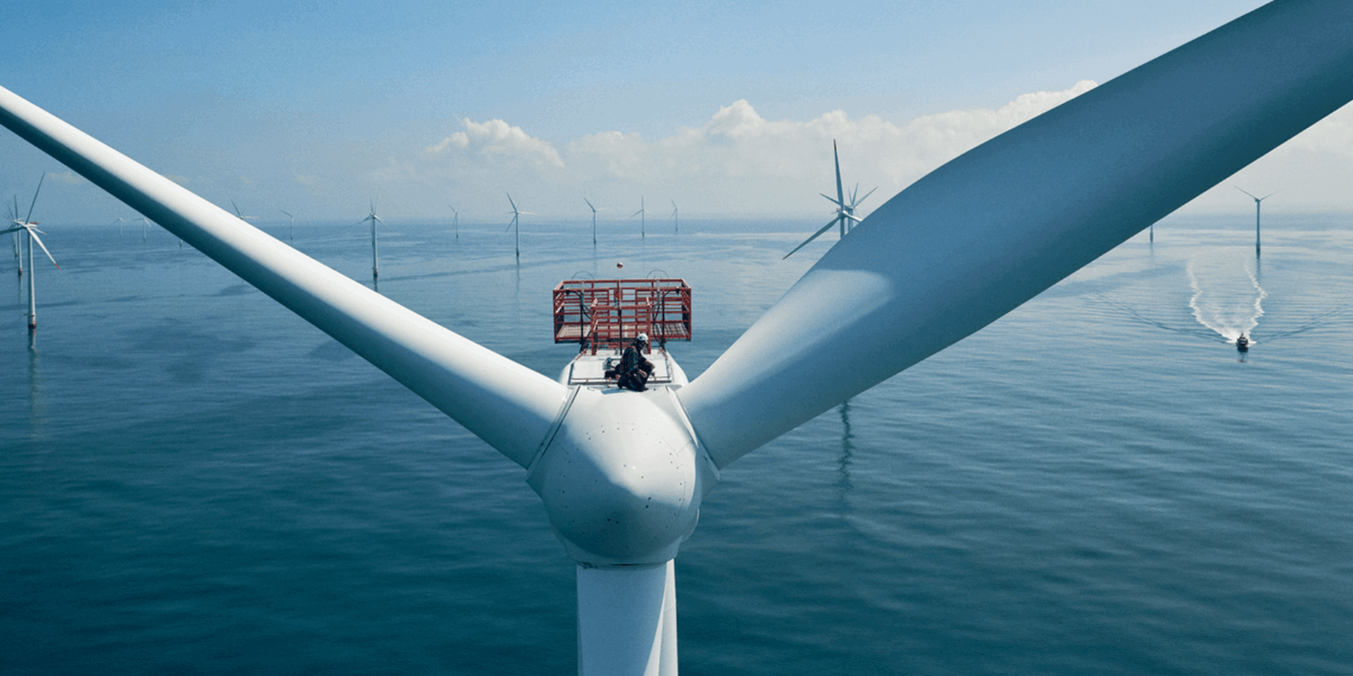 Mannen boven op een windmolen om onderhoudswerkzaamheden te doen