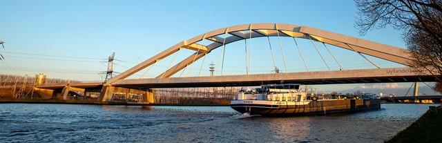 De biowarmte-installatie in Diemen. Boot op de rivier onder de brug door  | Vattenfall over biomassa