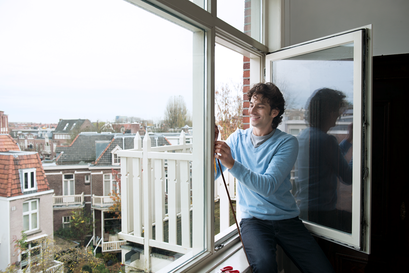 Man meet raam op voor het vervangen van kozijnen