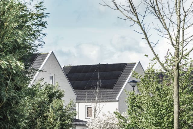 Zonnepanelen op het dak van een wit huis