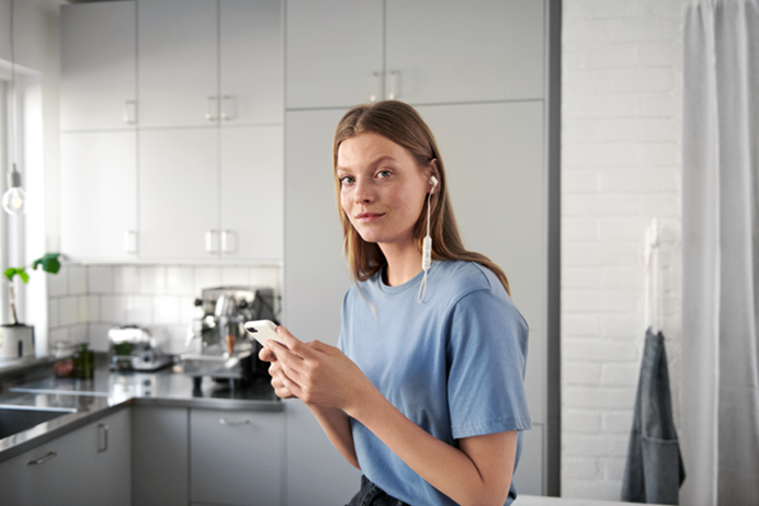 Vrouw checkt op haar telefoon de Energie-app van Vattenfall