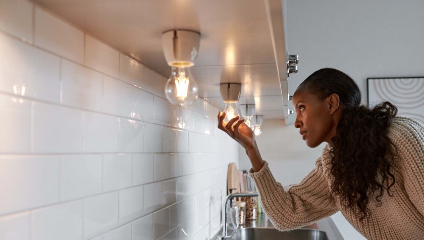 Mevrouw draait lamp in fitting