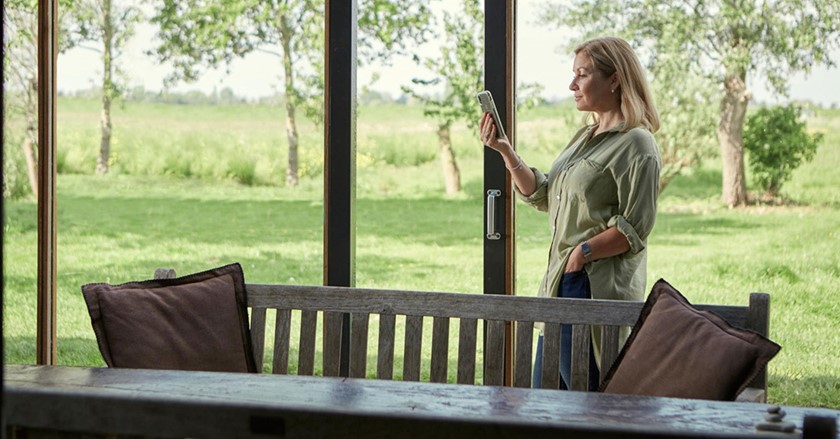 Vrouw kijkt op smarthpone om slim energieprijzen te vergelijken