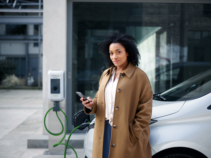Vrouw staat voor een bedrijf haar auto op te laden | MIA subsidie voor mkb
