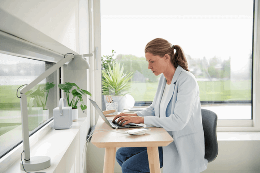 Mevrouw achter bureau bekijkt Mijn Vattenfall op laptop
