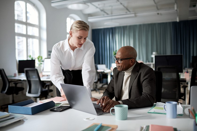 Collega's zitten samen achter een bureau te overleggen