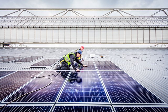 2 mannen leggen zonnepanelen op het dak